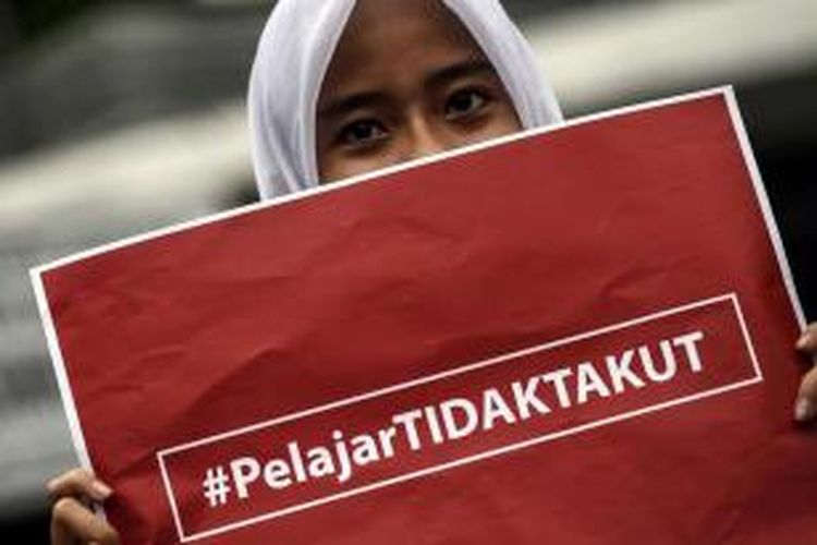 Pelajar memegang poster bertuliskan 'pelajar tidak takut' saat aksi solidaritas pasca-ledakan di kawasan Jalan MH Thamrin, Jakarta, Jumat, 15 Januari 2016. Sehari setelah ledakan dan aksi baku tembak di area jantung Ibu Kota itu, warga mencoba kembali beraktivitas seperti sedia kala.