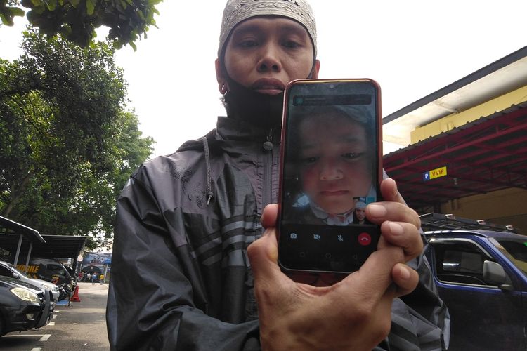 Rohendi tengah memperlihatkan hasil tangkapan layar video call terakhir saat anaknya yang nangis ingin pulang, di Mapolrestabes Bandung, Jumat (1/10/2021).
