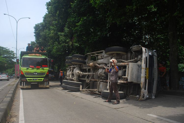 Truk molen yang mengangkut semen terbalik setelah terlibat kecelakaan dengan mobil angkot di Jalan Raya Abdullah bin Nuh, Kota Bogor, Sabtu (17/2/2018). Dalam peristiwa tersebut, dua orang penumpang angkot meninggal dunia.