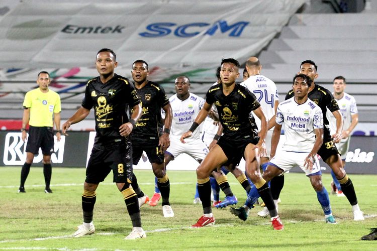 Pemain Persebaya Surabaya Koko Ari Araya (tengah) bersiap berebut bola dengan pemain Persib Bandung saat pertandingan pekan 32 Liga 1 2021-2022 yang berakhir dengan skor 1-1 di Stadion Kapten I Wayan Dipta Gianyar, Sabtu (19/3/2022) malam.