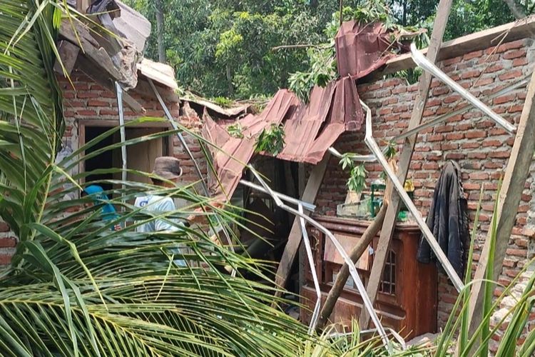 Warga berusaha membantu merapihkan rumah Kholil yang rusak akibat tertimpa pohon tumbang pada Rabu (21/2/2024) petang. Istri, bayi, serta anak perempuan nya nyaris menjadi korban reruntuhan.