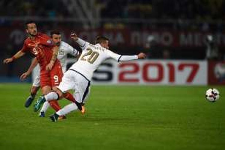 Penyerang Makedonia, Ilija Nestrovoski, melepaskan umpan saat dikawal pemain Italia, Federico Bernardeschi, pada laga di Skopje, Minggu (9/10/2016). 