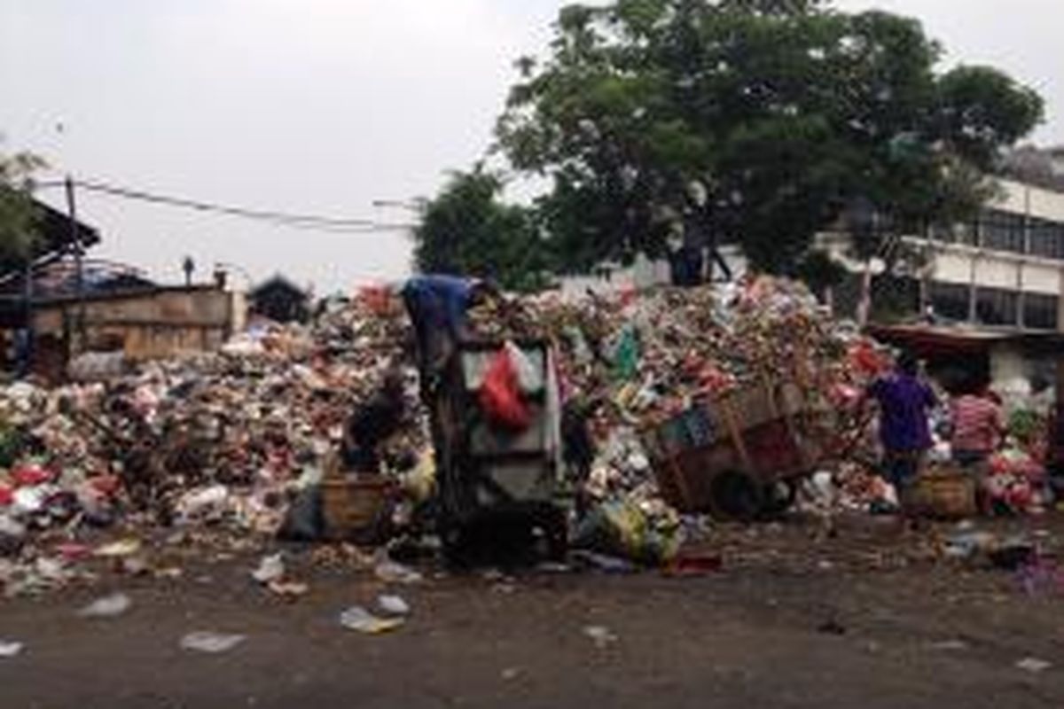 Pemungut memilah sampah di depan tumpukan sampah TPS Pasar Minggu pada Kamis, (5/11).