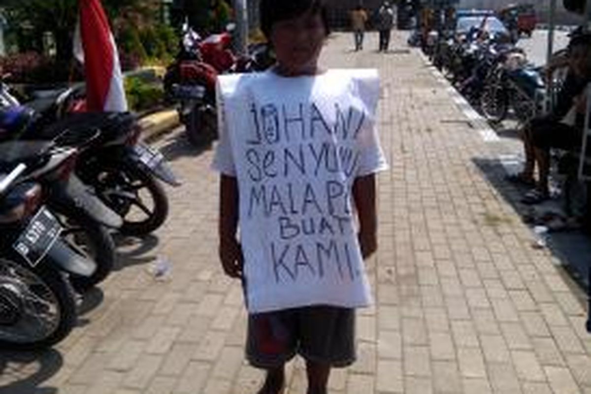 Salah satu spanduk yang dibawa warga kampung kandang dalam melakukan aksi unjuk rasa di kantor Wali Kota Jakarta Utara, Kamis (22/5/2014).