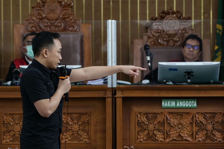 Terdakwa kasus pembunuhan berencana Brigadir J atau Nofriansyah Yosua Hutabarat, Ricky Rizal memeragakan adegan penembakan saat menjalani persidangan di Pengadilan Negeri Jakarta Selatan, Senin (9/1/2022).