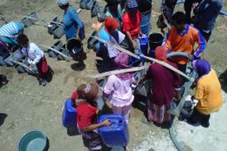 Warga Desa Bujur Barat mengangkut air dari hasil bantuan Badan Penanggulangan Bencana Daerah (BPBD) Pamekasan.