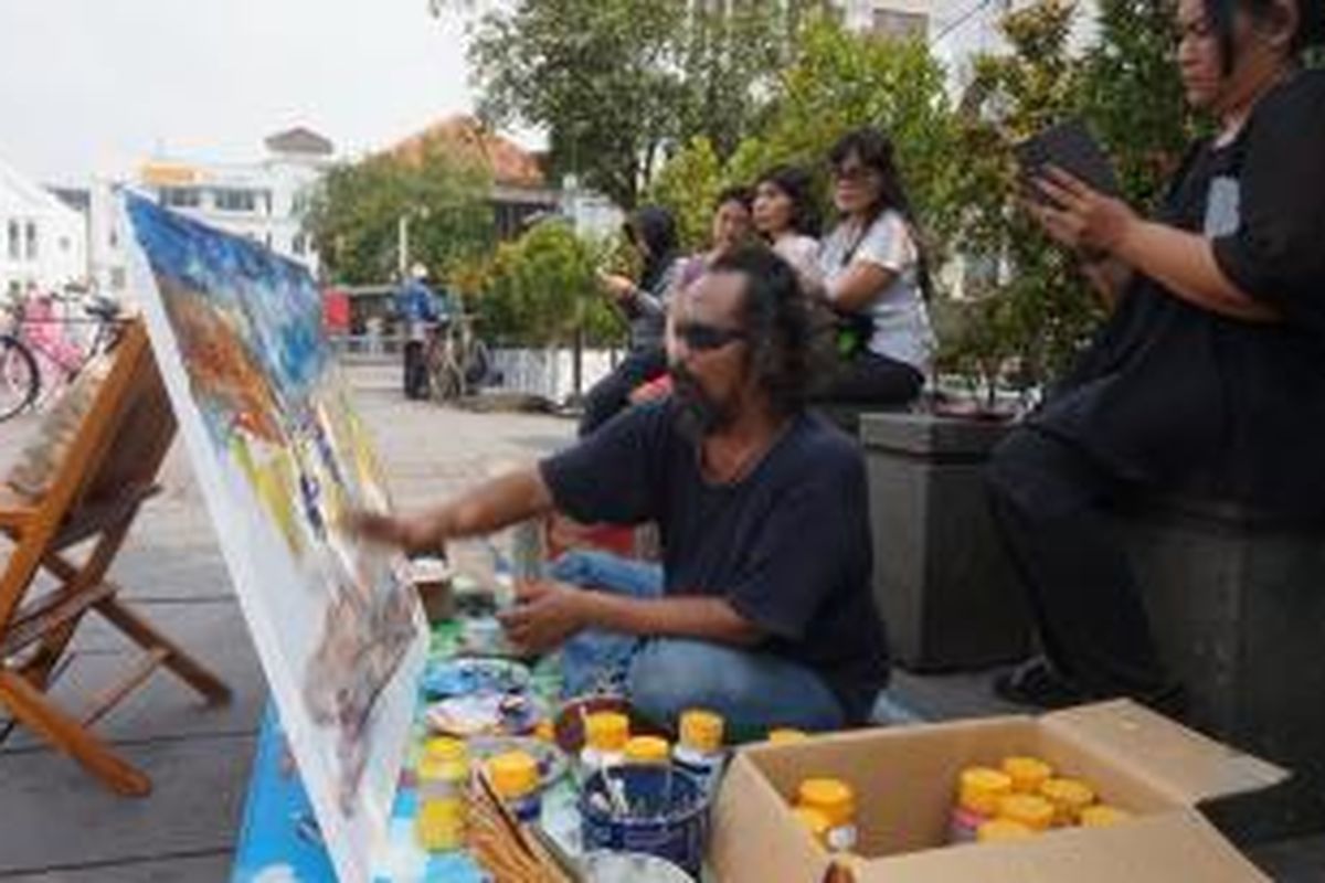 Pelukis on the spot Bayu Wardhana melukis Kota Tua, Kamis (25/6/2015).