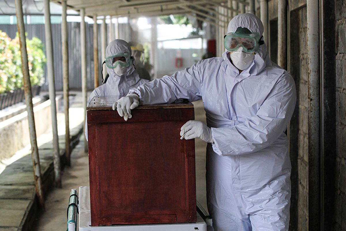 Hospital personnel at RSUD Bogor wheel out a coffin containing the remains of a patient who died of Covid-19 on Monday (11/5/2020)