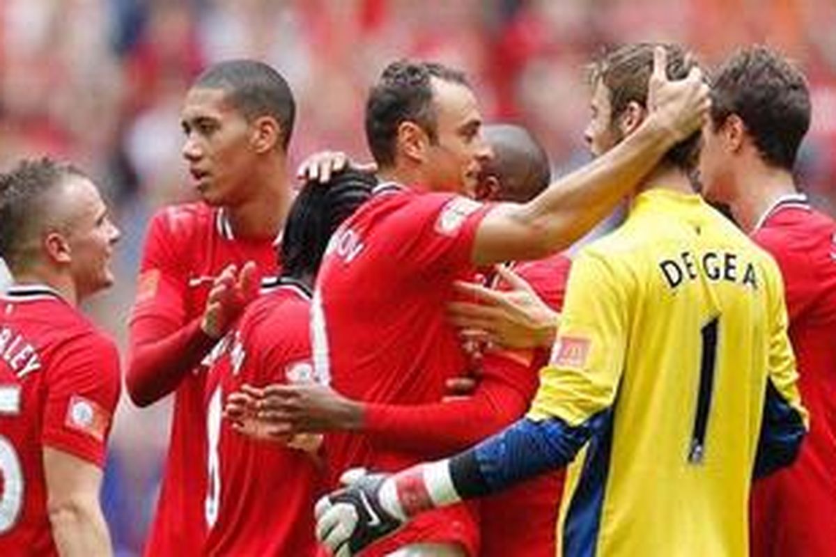 Penyerang Manchester United, Dimitar Berbatov merangkul kiper David De Gea, usai pertandingan Community Shield, melawan Manchester City, di Wembley, Minggu (7/8/2011).