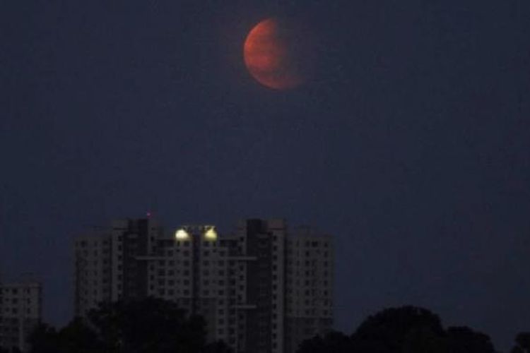 Gerhana bulan terlihat di Bhubaneswar, India, 8 Oktober 2014. Warna merah pada gerhana bulan dipengaruhi oleh pembiasan atmosfer Bumi, disebut dengan bulan merah darah.