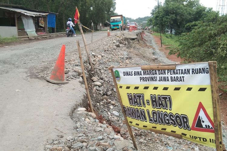 Kendaraan melintas di Jalan Badami-Loji, Kampung Nyangkokot, Desa Wanasari, Kecamatan Telukjambe Barat, Kabupaten Karawang, Jawa Barat, yang longsor sejak setahun terakhir, Senin (17/1/2022).