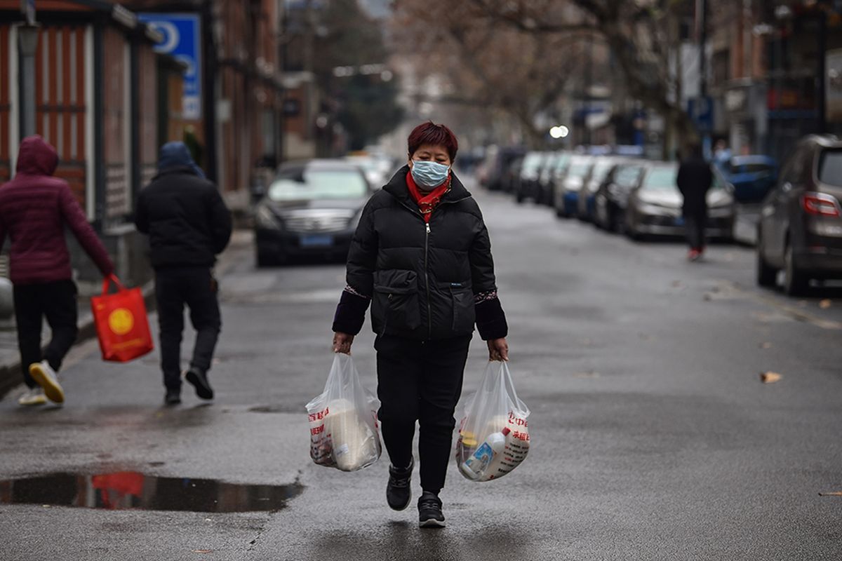 Seorang perempuan warga kota Wuhan, China, mengenakan masker untuk menghindari terinfeksi virus corona yang mematikan saat berbelanja di sebuah pasar di kota Wuhan, Minggu (26/2/2020).