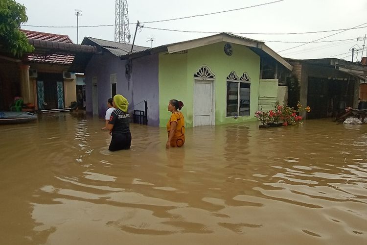 Sejumlah warga di Desa Sei Rampah, Kecamatan Sei Rampah melintasi banjir yang terjadi akibat tingginya curah hujan. Sedikitnya 1.750 rumah terendam banjir di kecamatan ini pada Rabu (3/11/2021). 