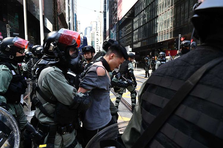 Seorang pria diamankan oleh polisi antihuru-hara saat berlangsungnya aksi di Hong Kong, Senin (11/11/2019). Aksi menolak usulan UU Ekstradisi diwarnai kericuhan di Hong Kong yang terjadi sejak Juni lalu kini makin meluas dengan desakan pengusutan kebrutalan polisi hingga hak untuk memilih pemimpin sendiri.