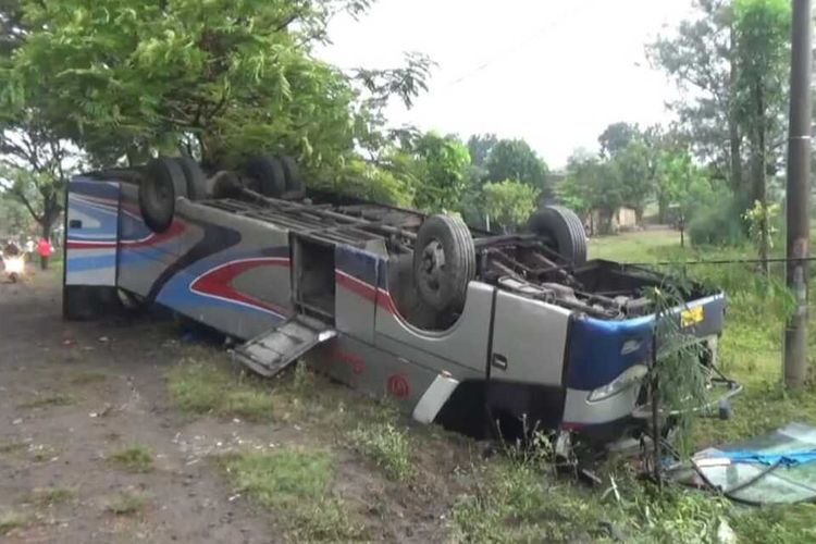 TERBALIK-Satu bus jurusan Surabaya-Madiun terbalik setelah terlibat tabrakan karombol di Jalan Raya Surabaya-Madiun KM 139-140, Desa Sugihwaras, Kecamatan Saradan, Kabupaten Madiun, Jawa Timur, Kamis (17/6/2021) pagi. 