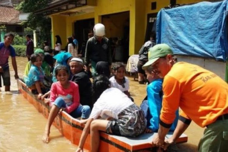Petugas keamanan wilayah menarik perahu untuk mengantarkan keluarga mempelai pria ke lokasi pernikahan di Kampung Bojong Asih, Desa Dayeuhkolot, Kecamatan Dayeuhkolot, Kabupaten Bandung, Kamis (9/3/2017). 
