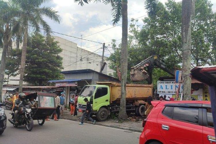 Petugas mengangkut material bangunan liar milik PDI-P yang dirobohkan di Jalan Juanda Medan, ke atas truk sampah milik Pemkot Medan, Rabu (14/9/2022). 

