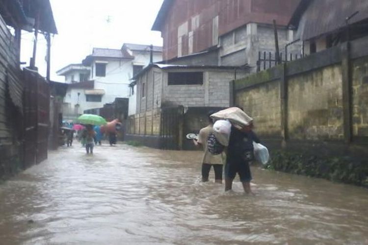 Warga di Malvinas, Dendengan Luar, Kecamatan Paal Dua, Kota Manado, Sulawesi Utara, mulai mengungsi karena banjir mulai merendam rumah warga, Kamis (26/1/2017).