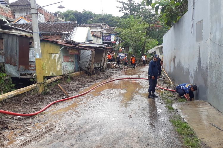 Petugas membersihkan pemukiman warga pasca banjir.