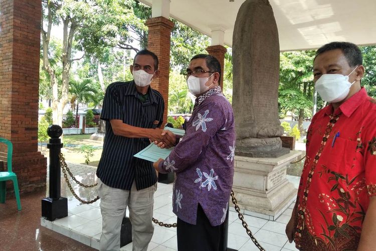 Susilo (kiri) menerima imbalan dari BPSMP Sangiran karena berjasa menyelamatkan fosil di Nganjuk, Jumat (12/8/2022).