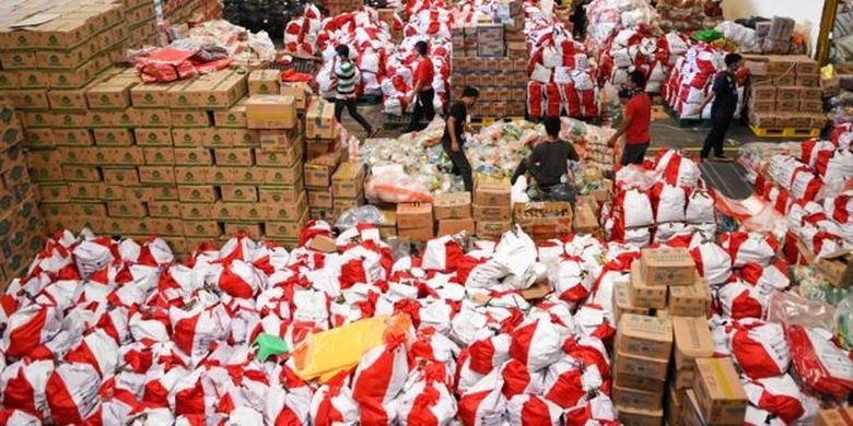 Pekerja mengemas paket bantuan sosial (bansos) di Gudang Food Station Cipinang, Jakarta, Rabu (22/04). 
