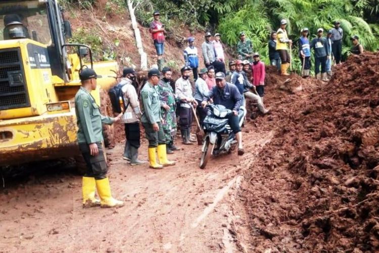 Seorang pengendara sepeda motor berupaya melewati ruas jalan yang tertutup material longsor di wilayah Kecamatan Takokak, Kabupaten Cianjur, Jawa Barat, longsor, Rabu (3/11/2021).