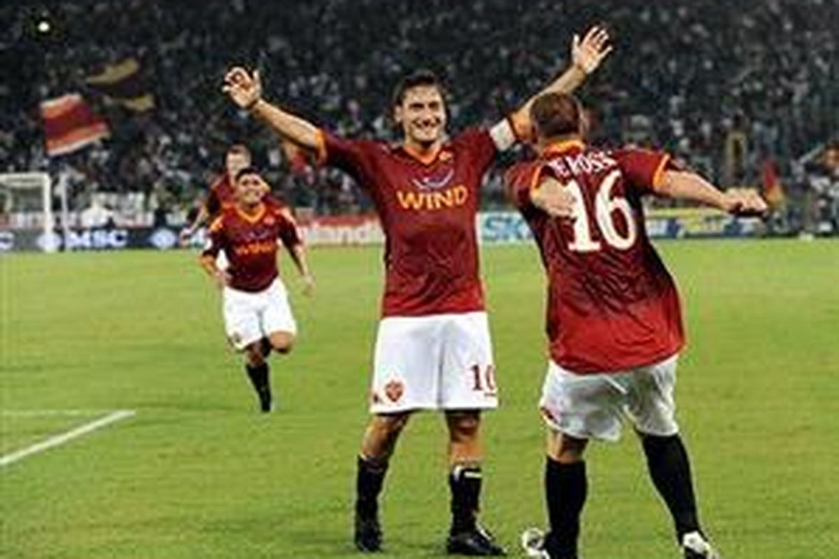 Kapten AS Roma, Fransesco Totti (tengah) dan Daniele De Rossi merayakan gol ketiga mereka ke gawang Fiorentina dalam lanjutan Serie-A, Minggu (20/9).
