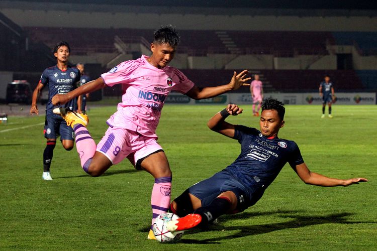 Pemain Arema FC Bagas Adi Nugroho menghalau tendangan pemain Persita tangerang Ahmad Nur Hardianto saat pertandingan pekan kesembilan Liga 1 2021-2022 yang berakhir dengan skor 2-2 di Stadion Sultan Agung Bantul, Rabu (27/10/2021) malam.