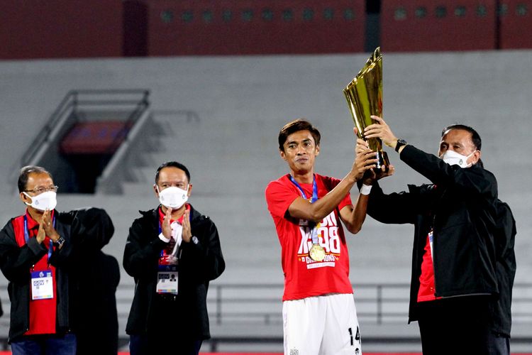 Kapten Bali United Fadhil Sausu menerima piala fuara Liga 1 2021-2022 dari metia umum PSSI Mochamad Iriawan seusai laga terakhir pekan 34 melawan Persik Kediri di Stadion Kapten I Wayan Dipta Gianyar, Kamis (31/3/2022) malam.