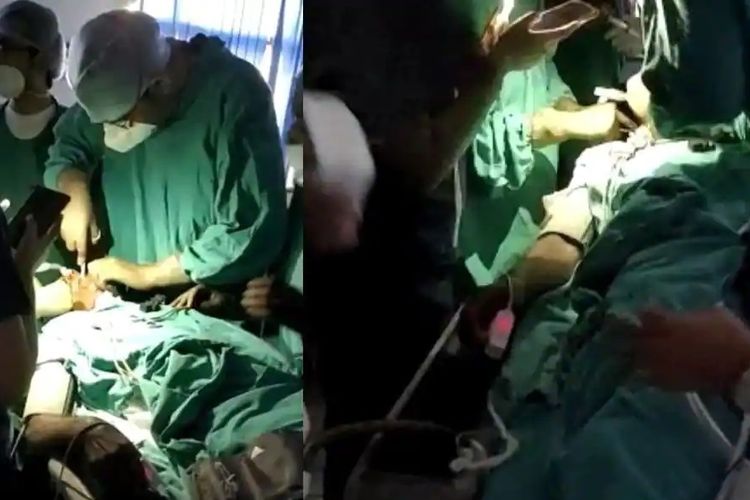 Dua gambar yang viral memperlihatkan seorang dokter dan dua perawat di rumah sakit Universitas Banaras HIndu, India mengoperasi pasien dengan salah satu staf menyalakan senter di ponsel sebagai penerangan.