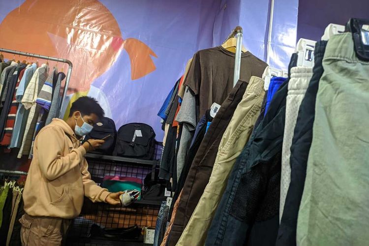 Muda - mudi tengah memilih pakaian di Thrift Vaganza di Gramedia World Karawang, Minggu (5/12/2021).