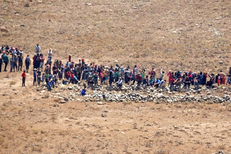 Warga Suriah yang melarikan diri dari kampung halaman mereka berjalan mendekati perbatasan dengan wilayah Dataran Tinggi Golan yang diduduki Israel.