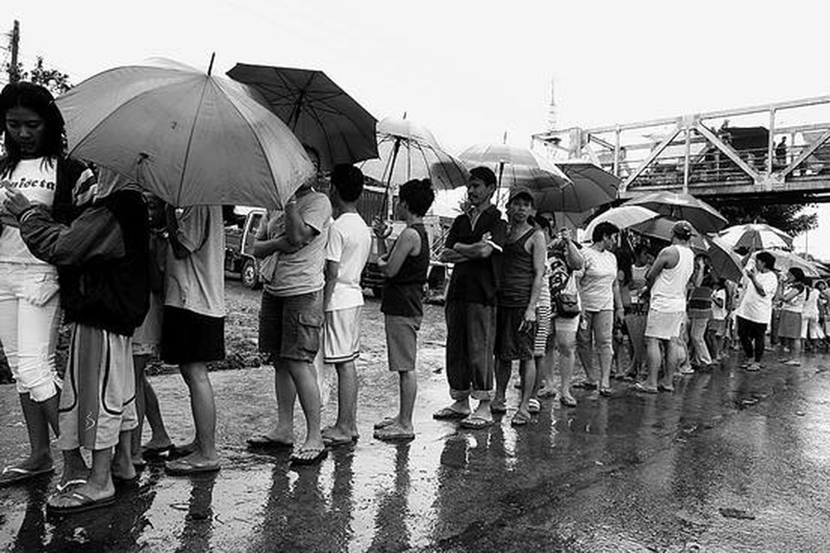 Warga Filipina antre untuk membeli beras bersubsidi dari pemerintah di sebuah jalan di Quezon City, Manila utara, Senin (14/4). Para pejabat Filipina menepis kemungkinan negara akan kacau akibat protes yang dipicu pangan langka dan harganya mahal, seperti yang telah menimpa Haiti, di mana Perdana Menteri Jacques Edouard Alexis dijatuhkan oleh Senat, Sabtu (12/4). Meskipun demikian, Pemerintah Filipina sangat gencar mendistribusikan beras bersubsidi untuk mencegah protes besar-besaran.  