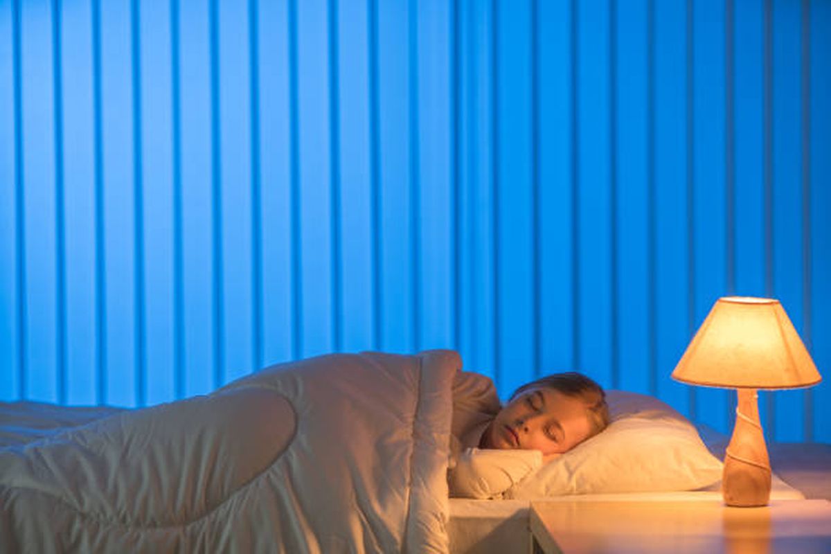 Ilustrasi tidur dengan lampu menyala.