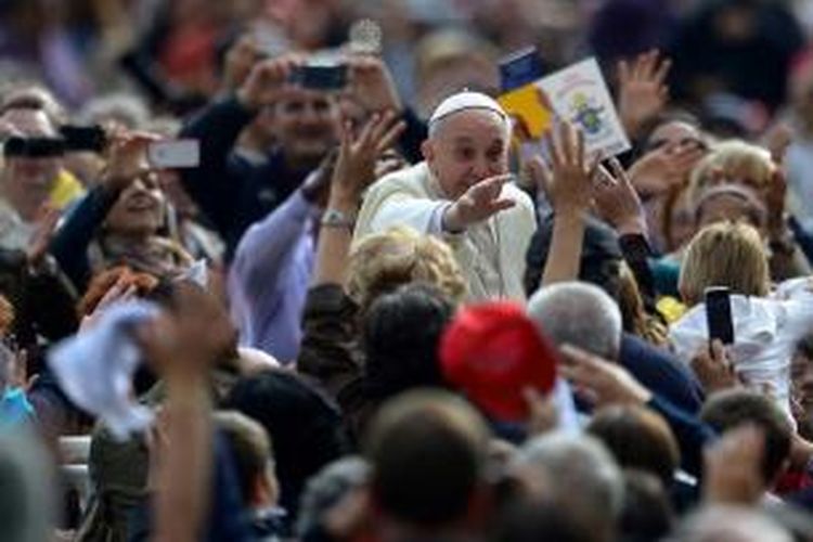 Paus Fransiskus menyapa umat saat tiba untuk pertemuan umum mingguan di Alun-alun St Peter, Vatikan, 9 Oktober 2013.