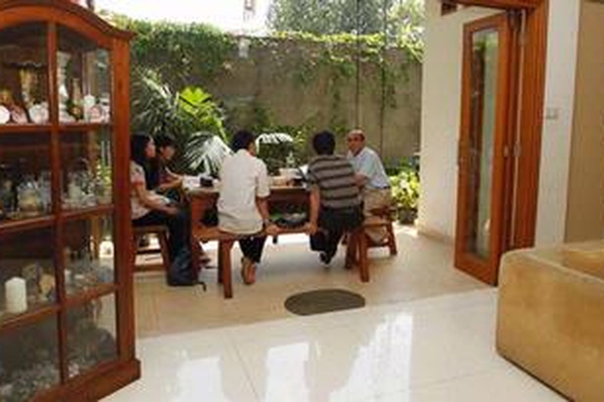 Di teras belakang,  meja dan kursi dari kayu ditata seolah mengundang tamu untuk mengobrol atau sekedar santai. 