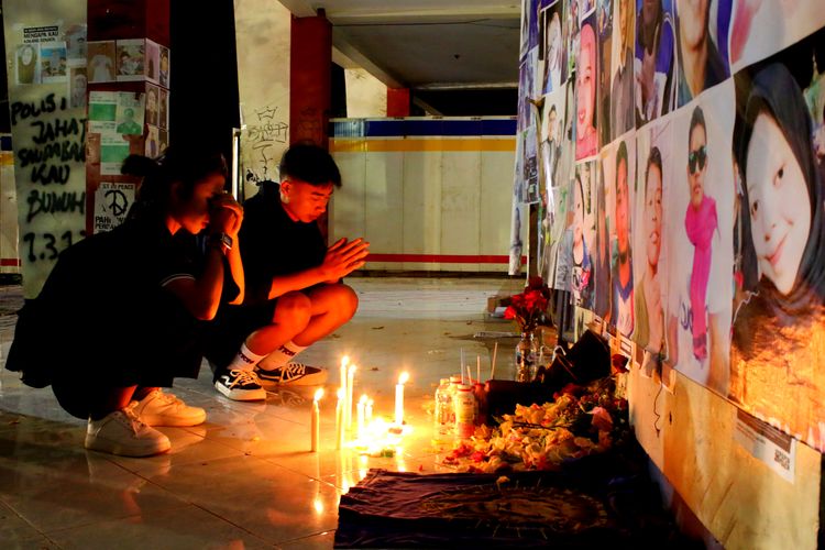 Peziarah korban meninggal saat kirim doa memperingati satu tahun Tragedi Kanjuruhan di gate 13 Stadion Kanjuruhan Kabupaten Malang, Minggu (1/10/2023) malam.