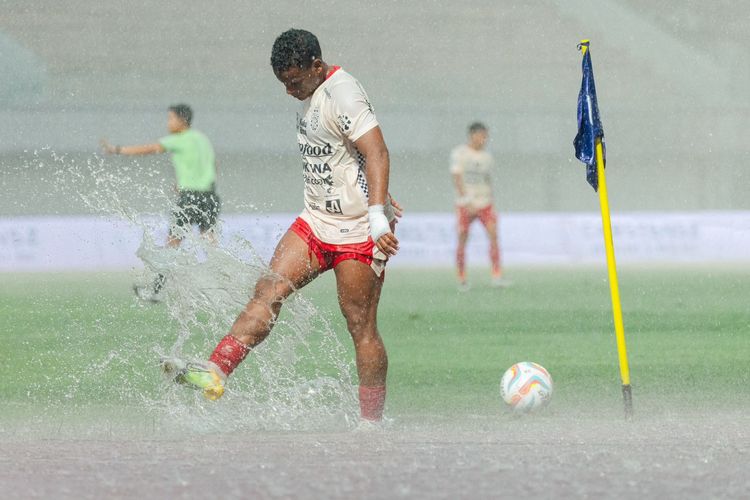 Pemain Bali United Eber Bessa menendang genangan air hujan akibat hujan deras saat laga pekan ke-22 Liga 1 2023-2024 melawan Dewa United yang berakhir dengan skor 1-1 di Stadion Indomilk Arena Tangerang, Jumat (8/12/2023) sore. 