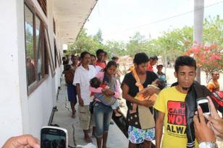 : Puluhan calon TKI ilegal saat didata identitas mereka di Dinas Tenaga Kerja dan Transmigrasi Kabupaten Timor Tengah Utara (TTU). Terlihat sejumlah calon TKI sementara menggendong bayi mereka.