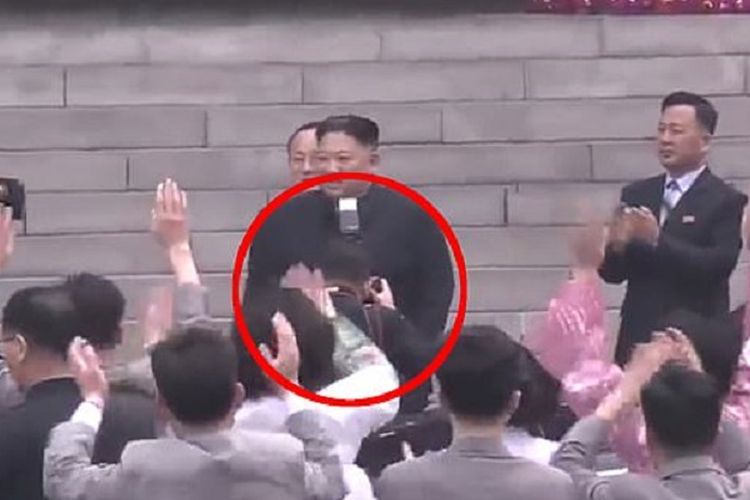 Inilah momen di mana fotografer bermarga Ri tertangkap mengarahkan kamera ke arah Pemimpin Korea Utara Kim Jong Un sehingga flash pun terlihat berada di leher. Ri langsung dipecat karena dianggap merusak kemuliaan tertinggi Kim.