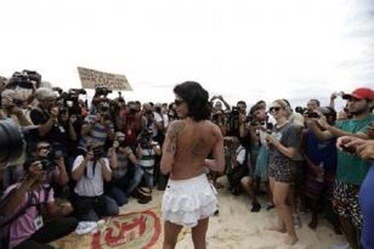 Seorang peserta aksi protes bertelanjang dada, Sabtu (21/12/2013) untuk menentang aturan larangan topless di pantai-pantai Brasil.