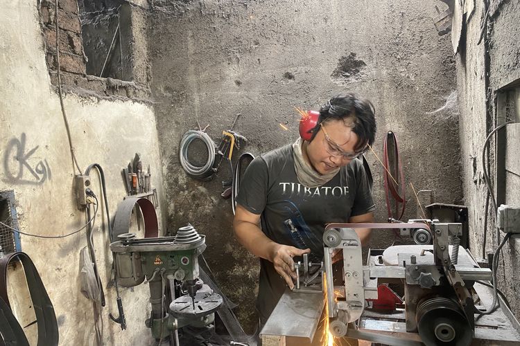 Dedi Junaedi (40 tahun), pengrajin logam asal Desa Cibatu saat melakukan proses penghalusan dan penajaman terhadap pisau sisit yang dibuatnya, Kamis (6/6/62024).