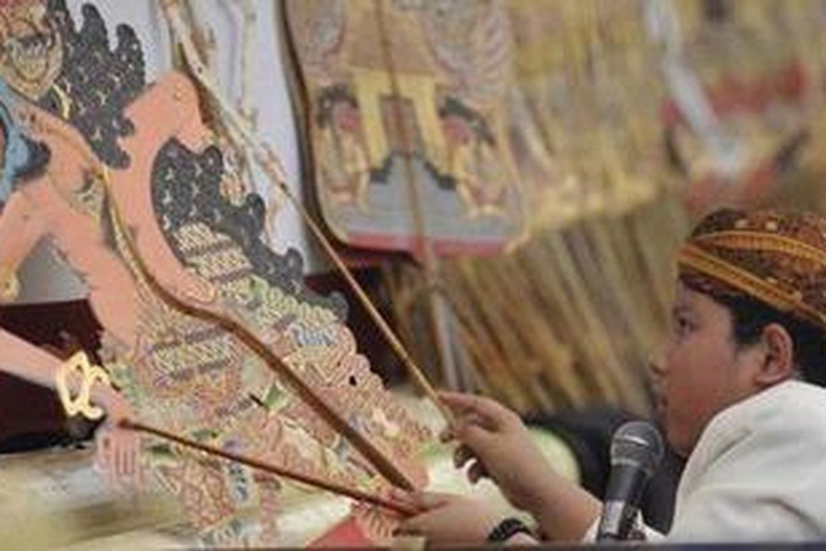 Dalang cilik Adam Ghifari memainkan lakon Kumbokarno Gugur pada pentas wayang kulit purwo di Festival Dalang Bocah 2011 di Museum Bank Indonesia, Jakarta, Selasa (19/7/2011). Festival juga diisi dengan pameran dan pelatihan pembuatan wayang untuk mengenalkan wayang sebagai warisan budaya bangsa khususnya kepada anak-anak. 