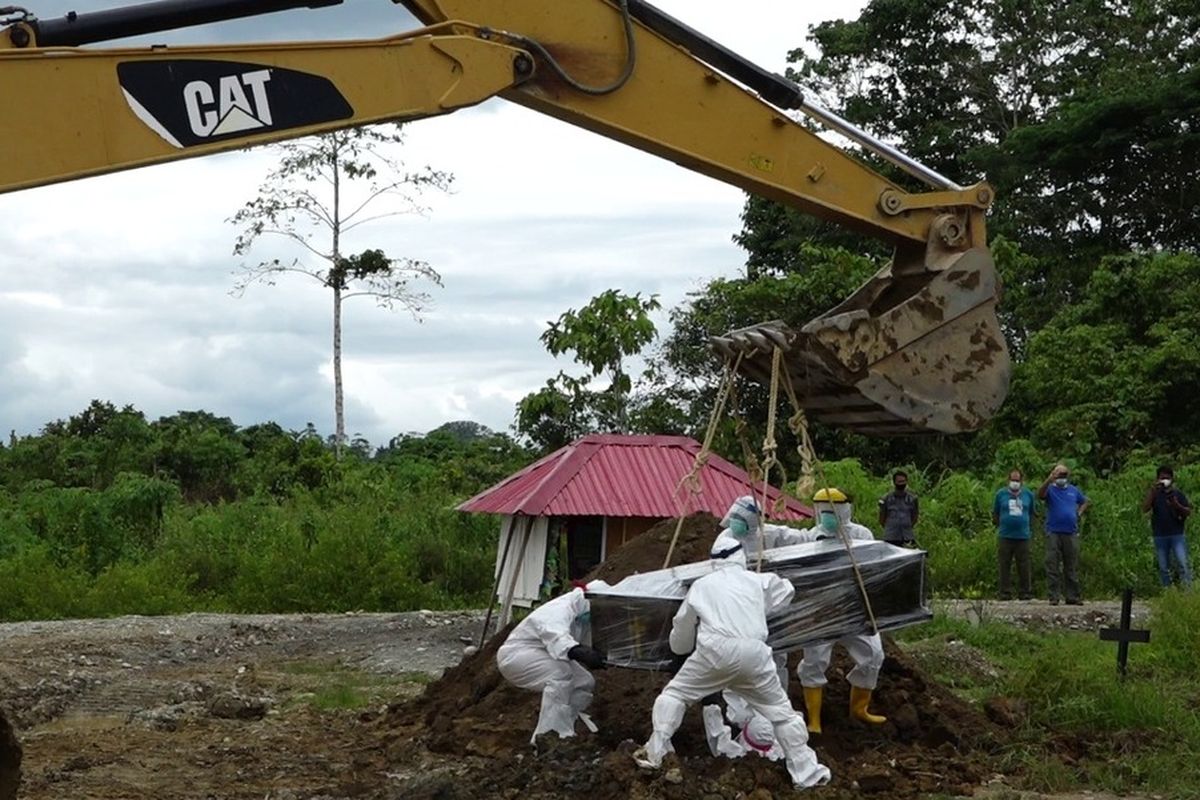 Medical workers in personal protective equipment bury a Ukrainian national identified as VP (58) in Timika, Papua on Wednesday (18/11/2020) in accordance with Covid-19 health protocols. VP tested positive for Covid-19 after he died of the coronavirus last weekend.