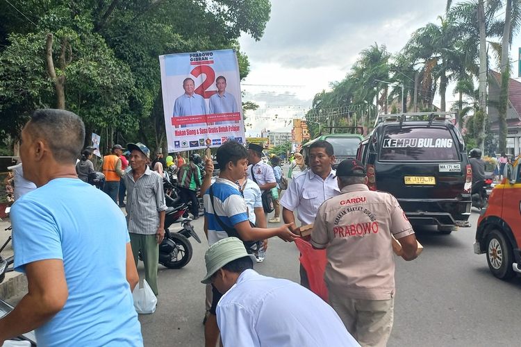 Anggota TKD Prabowo-Gibran membagikan susu dan makanan di Jalan Sutomo Pematang Siantar, Provinsi Sumut, Selasa (28/11/2023).