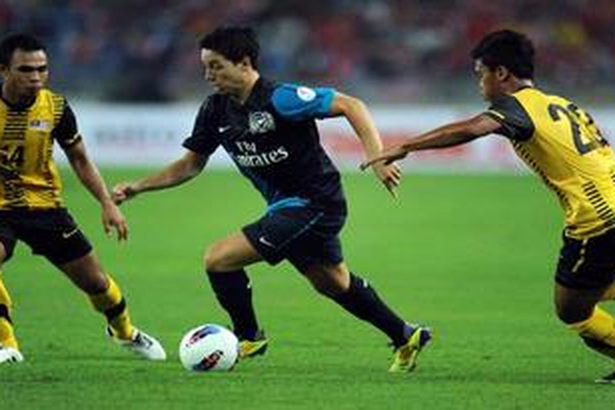 Gelandang Arsenal Samir Nasri menggiring bola di tengah kawalan dua pemain bek Malaysia Abdul Hadi (kiri) dan Helmi Remeli, dalam pertandingan persahabatan, di Stadion Bukit Jalil, 13 Juli lalu. 
