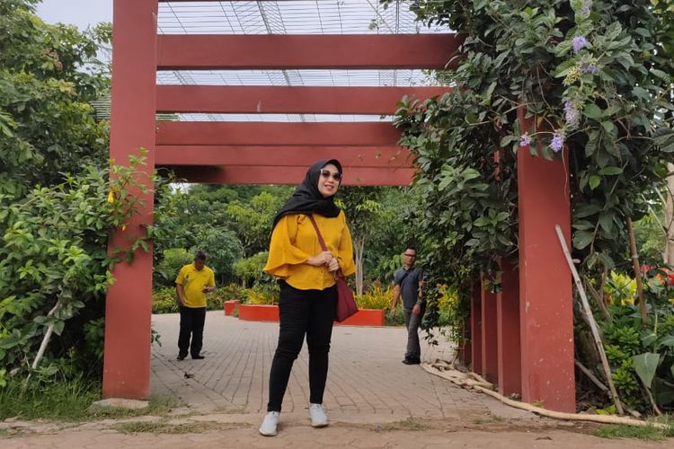 Seorang pengunjung berfoto dengan bunga matahari di Taman Harmoni Keputih, Kota Surabaya, Senin (27/1/2020).