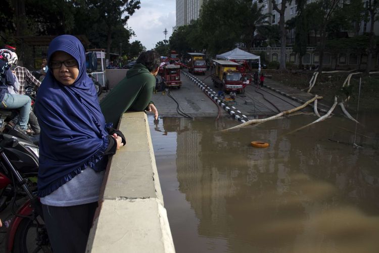 Warga antusias meyaksikan pengerjaan penyedotan air yang menggenangi Underpass Ghandi, Kemayoran, Jakarta Pusat, Minggu (2/2/2020). Jalan lintas bawah tersebut kembali tergenang banjir hingga ketinggian 2 meter.