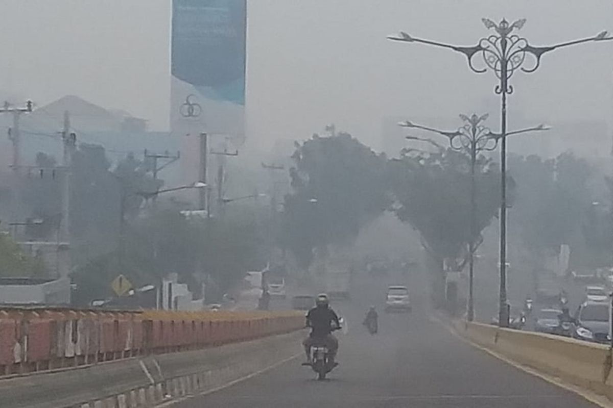 Kabut asap pekat dengan jarak pandang sekitar 300 meter di Jalan Jenderal Sudirman, Kota Pekanbaru, Riau, Jumat (13/9/2019).