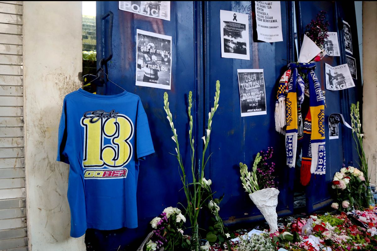 Kaos bertuliskan gate 13 tergantung di pintu bersama syal sebagai penghormatan kepada korban pasca tragedi yang terjadi pada pekan ke-11 Liga 1 2022-2023 seusai pertandingan bertajuk Derbi Jawa Timur, Arema FC melawan Persebaya Surabaya di Stadion Kanjuruhan Kepanjen, Kabupaten Malang, Selasa (4/10/2022) siang.